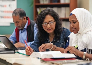 Twee vrouwen en een man studeren.